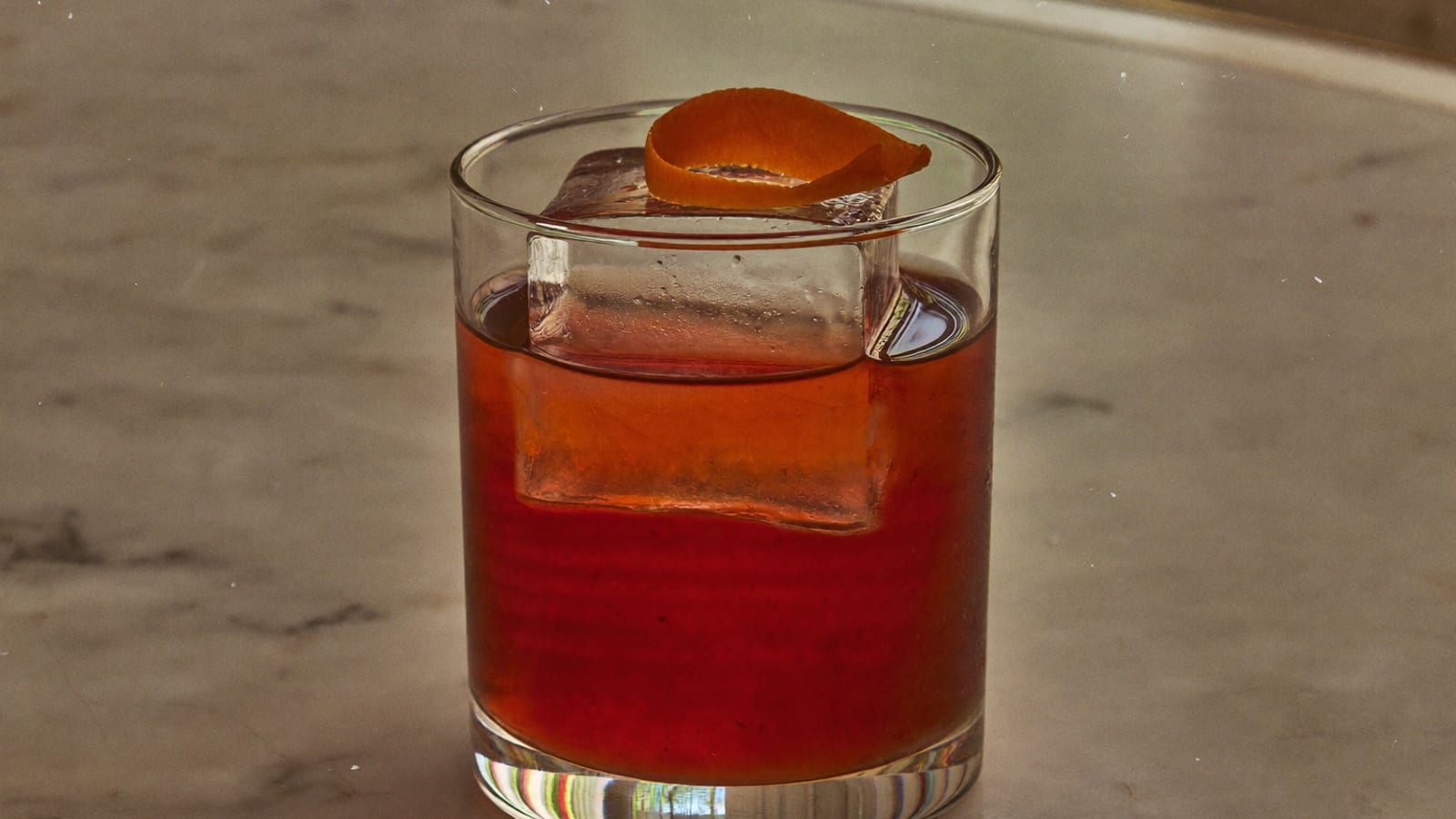 Un cocktail classique servi sur glace, sur un bar de marbre